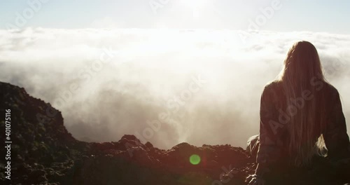 Caucasian woman on top of the Haleakala Crater watching sunrise photo