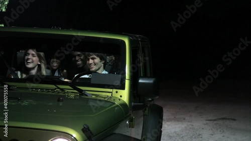 Men leaving women in car at night to go exploring with map photo