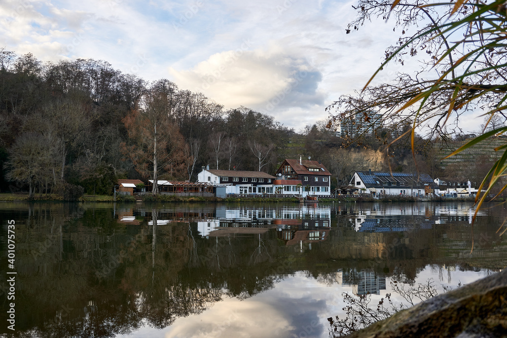 Boat house between the nineyards in stuttgart is reflection in the water of the neckar river