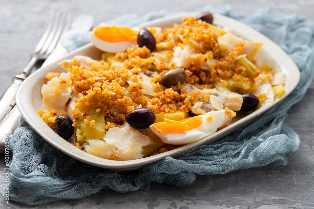 cod fish with sweet potato, boiled egg, olives and corn bread on white dish cod fish with sweet potato, boiled egg, olives and corn bread on white dish