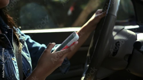 Close up of Hispanic woman texting while driving
