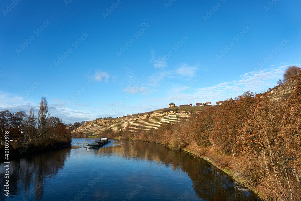 A boat on the neckar river in baden wuerttemberg between the vineyard mountain hill in the autumn sun