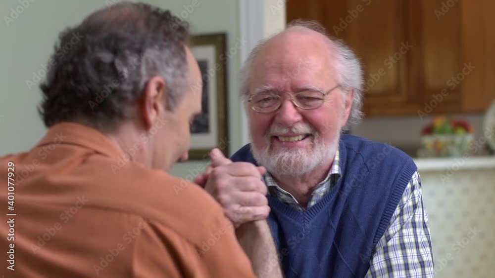 Close up of Caucasian men arm wrestling inside house Close up of Caucasian men arm wrestling inside house
