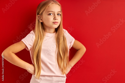 dreamy little girl in contemlation isolated in studio, caucasian child with long blond hair stand looking up