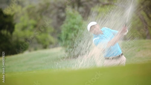 Black golfer celebrating hitting golf ball out of sand trap photo