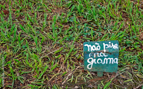 Sign board on the public square asking do not step on the grass, in portuguese language