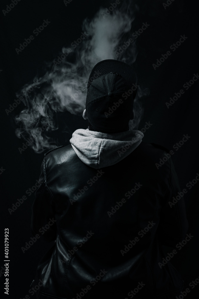 low key portrait of young men with hat, cap in the darkness.