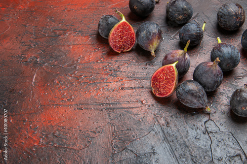 Side view of full fresh black mission figs split ones on colorful background photo