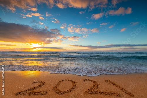 Fototapeta Naklejka Na Ścianę i Meble -  Happy New Year 2021 concept, lettering on the beach. Written text on the sea beach at sunrise.