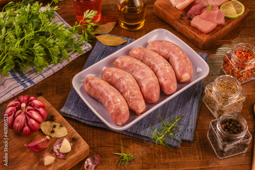 Brazilian pork leg sausage on white plate with spices and ingredients - Linguiça de pernil