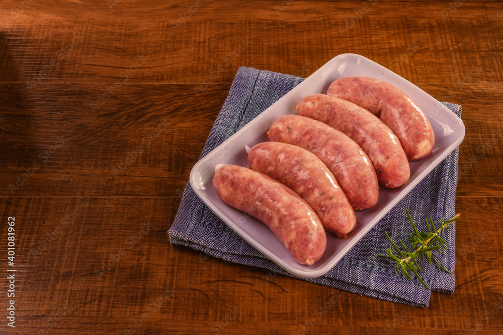 Brazilian pork leg sausage on white plate isolated on wood background