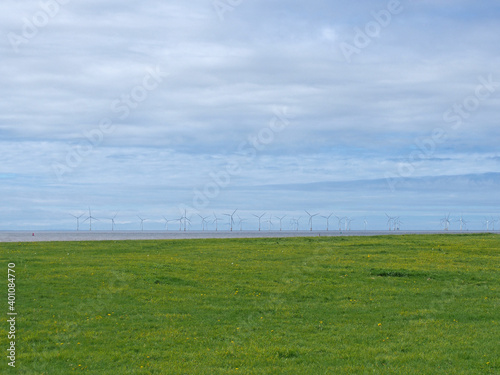 grass on the coast at blundell sands in crosby near southport with the wind turbines at burbo bank visible in the distance