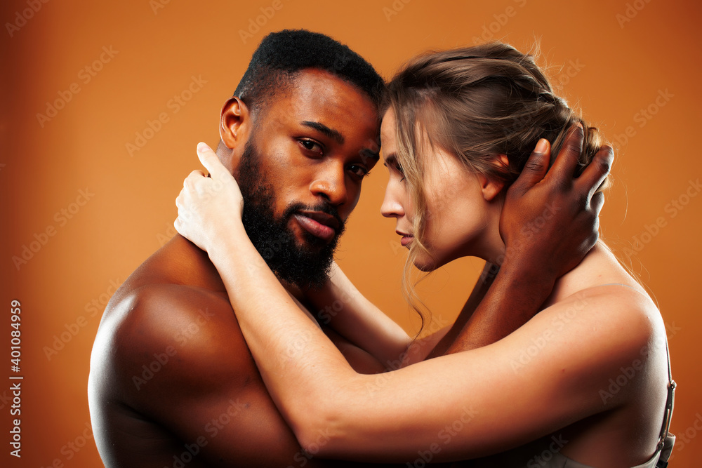 Obraz premium Young pretty couple diverse races together posing sensitive on brown background, lifestyle people concept