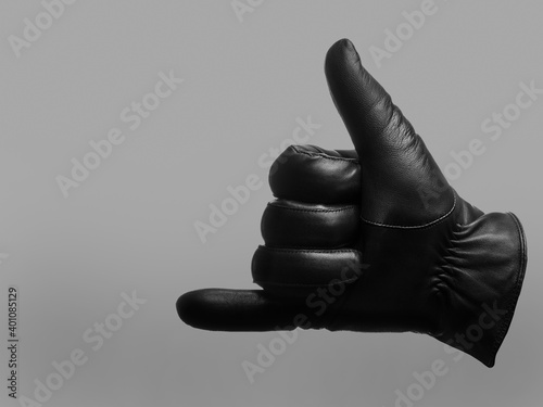 black leather glove shows drink gesture. isolated neutral background. copy space
