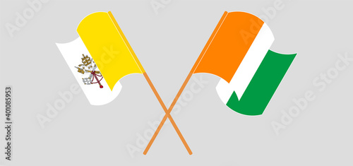 Crossed and waving flags of Vatican and Republic of Ivory Coast