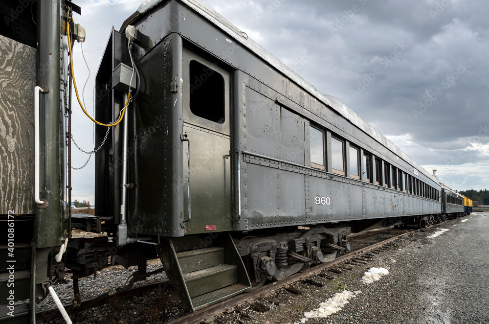 An empty abandoned train on the tracks in the city of Newport, Washington, USA, under cloudy skies during winter. An empty abandoned train on the tracks in the city of Newport, Washington, USA, under cloudy skies during winter.