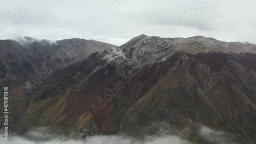 
Drone flying over mountain ranges with cliffs and slopes on which grow trees with forests. Clouds are below the mountain peaks. Aerial view Bosnia and Herzegovina. photo