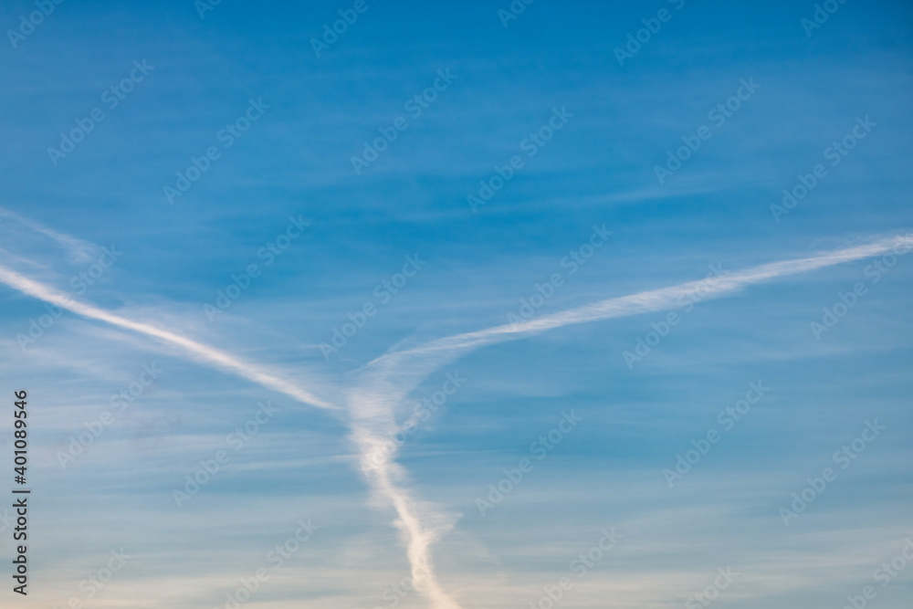 Several white condensation airplane trace in deep blue sky
