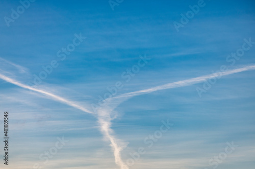 Several white condensation airplane trace in deep blue sky