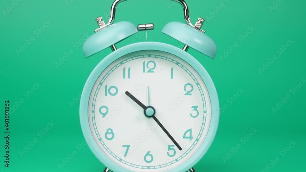 Closeup Zoom out, Alarm clock Ten o'clock isolated on green background, Time lapse 60 minutes. 