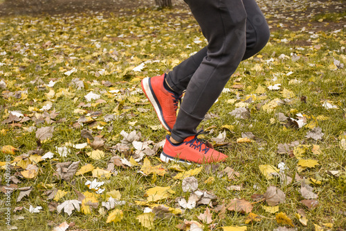 Close up of female feet as a runner. Women running in autumn leaves. Training exercise healthy lifestyle concept. Marathon and fitness on open air, outside, outdoors. Sport in park or forest.