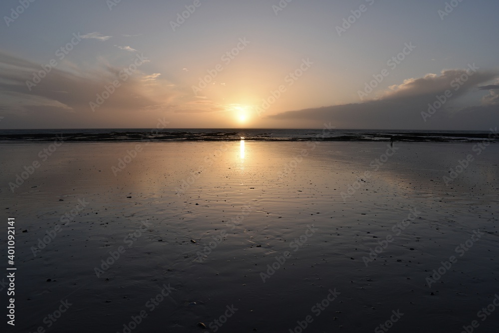 sunset over a low tide beach in Normandy 