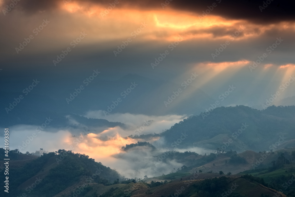 Gold light beam over a foggy mountain