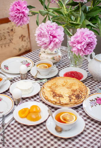 Traditional Russian or Ukrainian breakfast: homemade pancakes and tea with lemon. Traditional Russian or Belarusian cuisine. Maslenitsa. Stack of creps (aka blini).