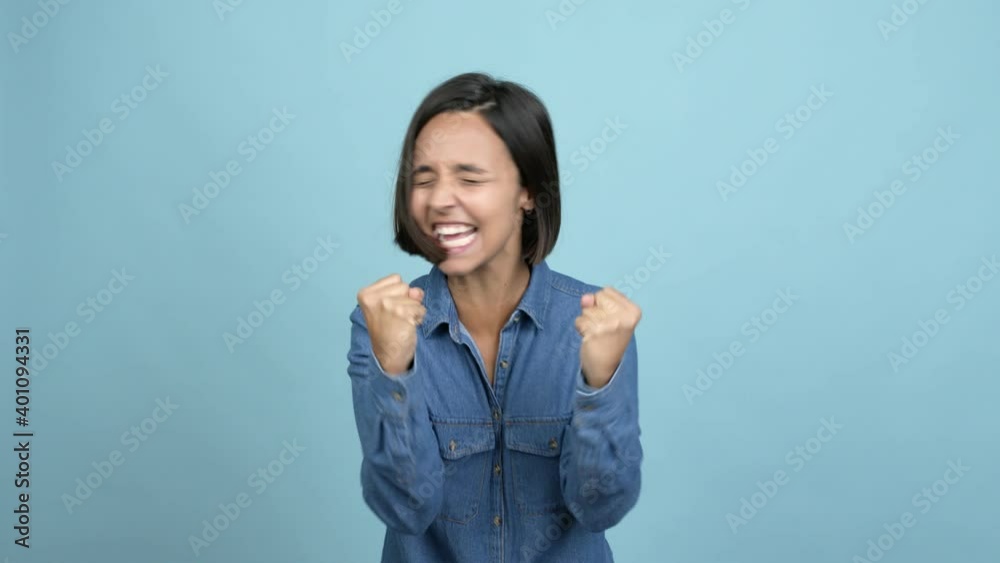 Young latin woman celebrating a victory and surprised to be successful over isolated background Young latin woman celebrating a victory and surprised to be successful over isolated background
