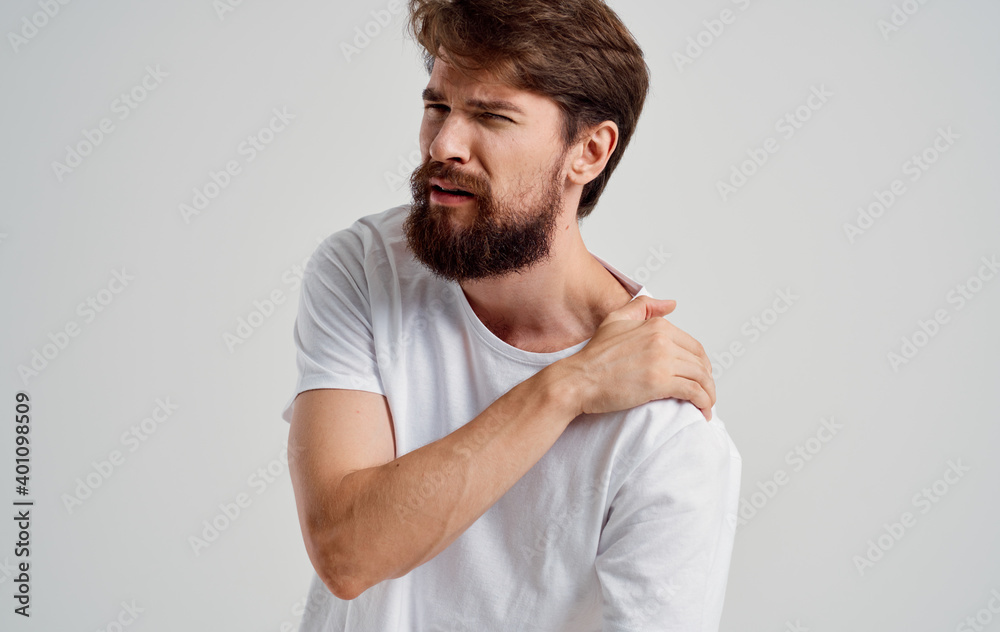 bearded man touching shoulder with hand pain dislocation medical intervention bearded man touching shoulder with hand pain dislocation medical intervention