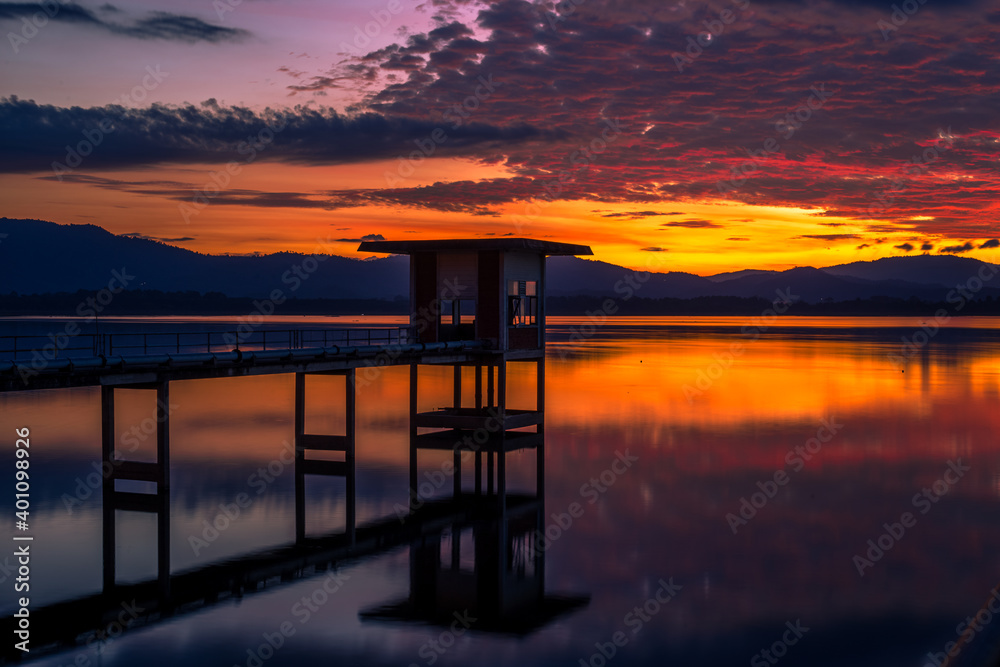 Close-up natural background of the morning scenery with the sun's rays hitting the water surface, the grassy trees on the edge of the reservoir, and the blurred wind, cool during the trip.