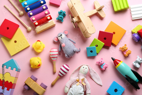 Different toys on pink background, flat lay photo