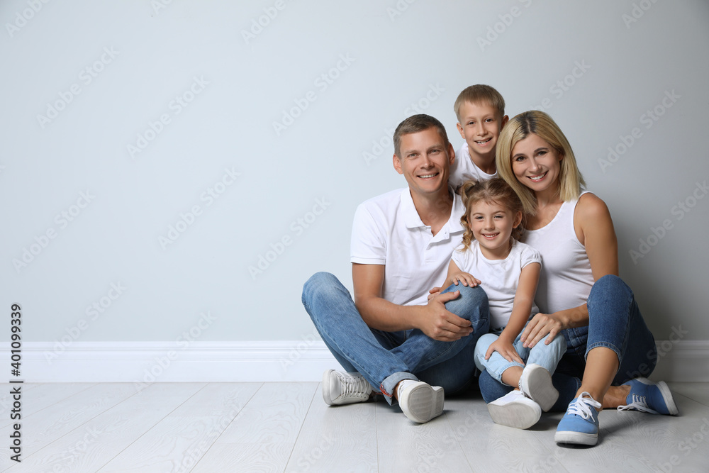 Happy family with children near grey wall. Space for text Happy family with children near grey wall. Space for text