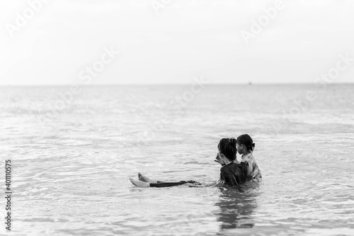 Black and white picture of mother and daughter in swimming suit on the beach