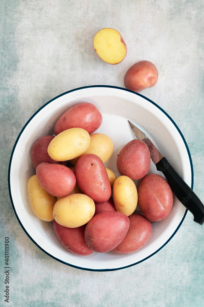 Red and white potatoes in a bowl with a knife. Red and white potatoes in a bowl with a knife.