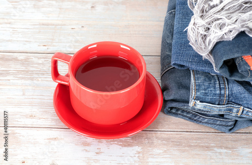 A cup of tea next to a stack of clothes