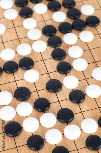 Looking down on the dense chess pieces on the Go board