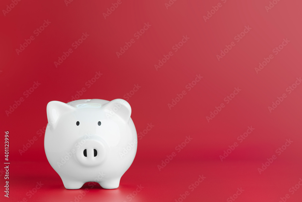A white piggy bank on the red background. A white piggy bank on the red background.