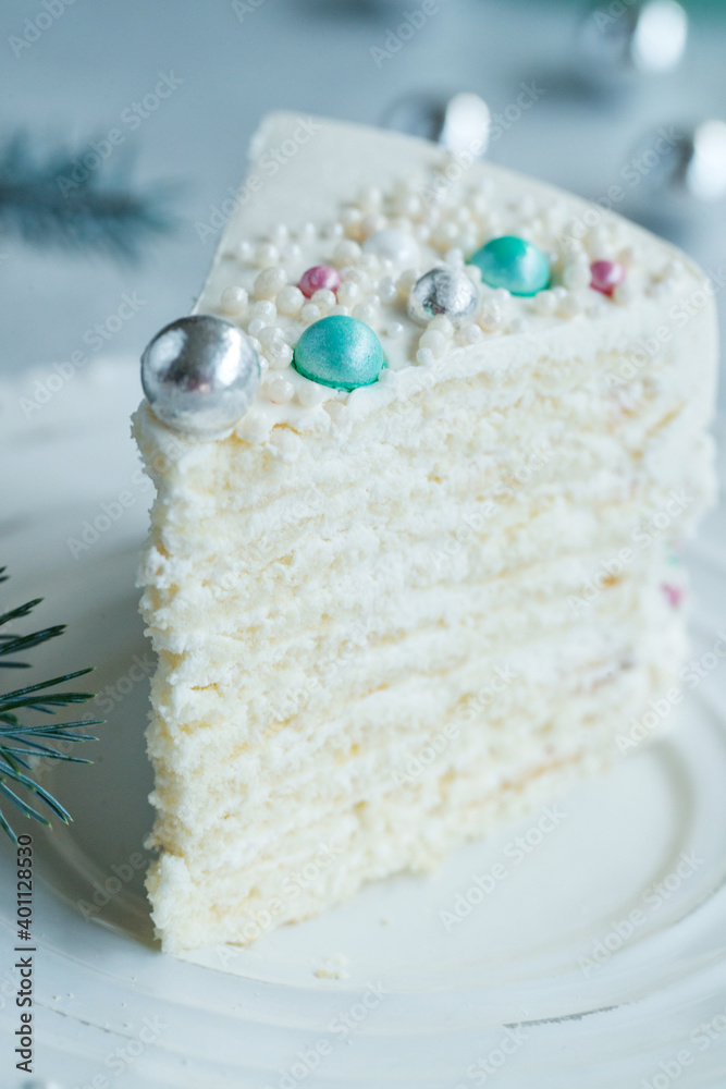 Vanilla sponge cake with cream and white chocolate decorate. Sliced piece of cake on white plate. Favorite dessert for celebrate event or birthday party. High quality photo.