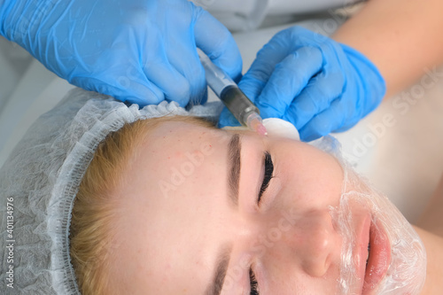 PRP therapy in beauty clinic. Cosmetologist doing injections of blood plasma to womans face to cure problem skin, closeup top view. Treatment of skin in cosmetology for young female.