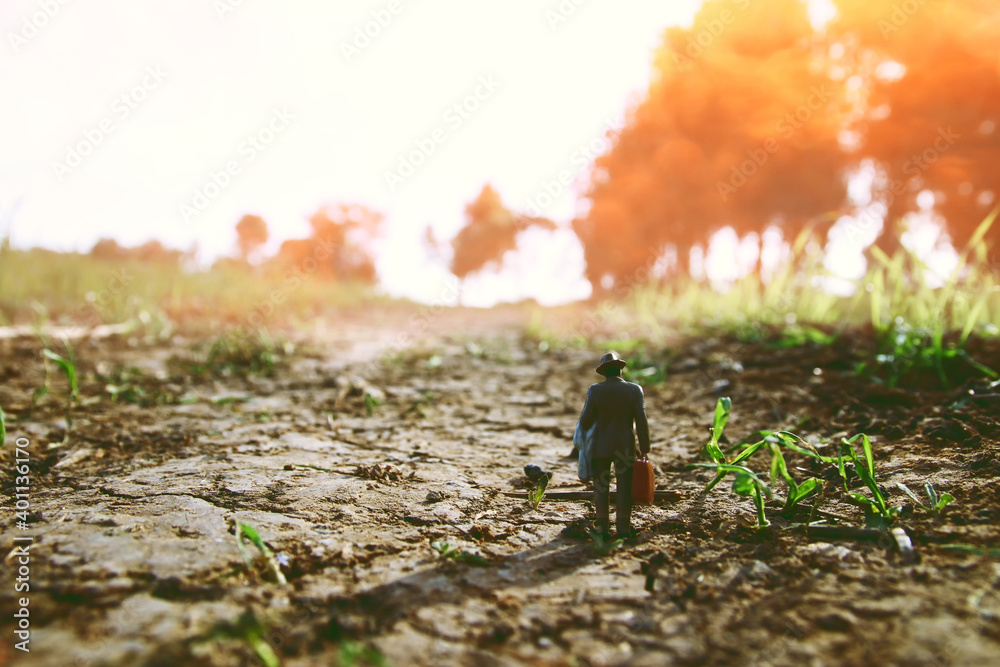Surreal image of mysterious man walking alone in field during sunset Surreal image of mysterious man walking alone in field during sunset