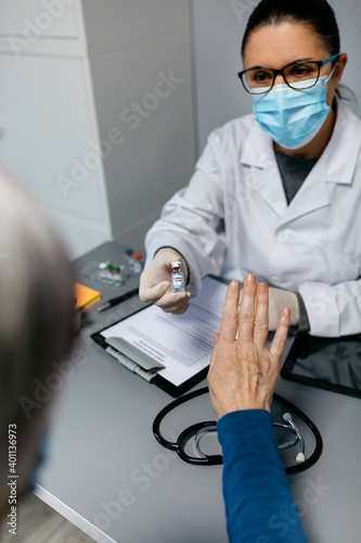 Female patient refusing the coronavirus vaccine offered by her doctor