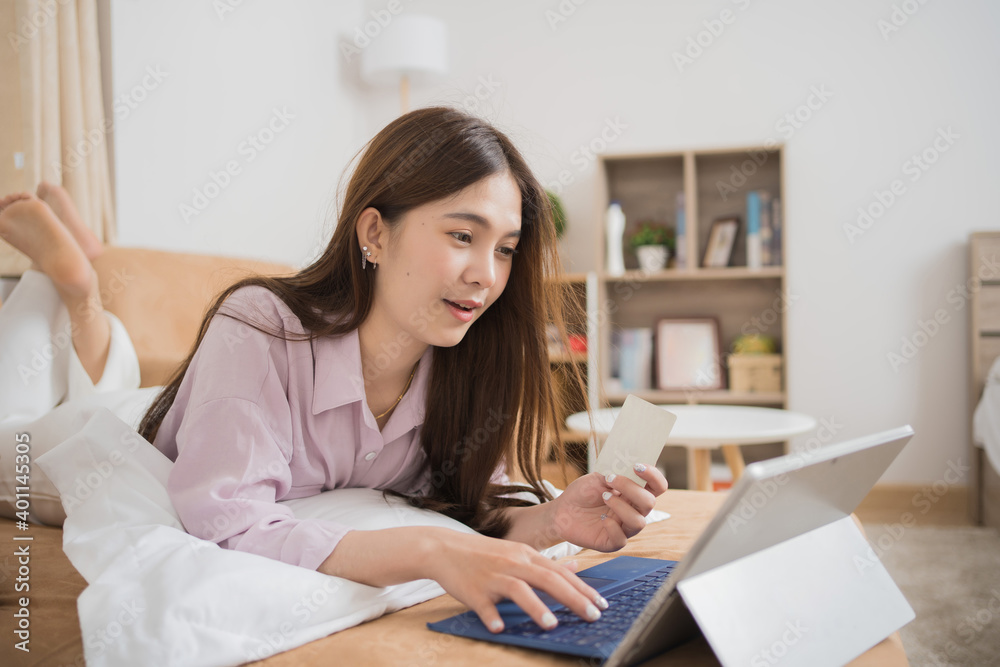 Asian woman is shopping online, she uses a credit card. Asian woman is shopping online, she uses a credit card.
