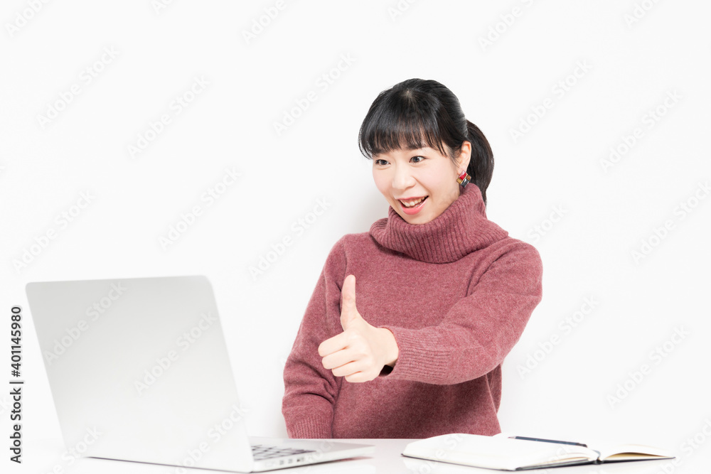 ノートパソコンを使いながら、いいねのジェスチャーをする女性 ノートパソコンを使いながら、いいねのジェスチャーをする女性