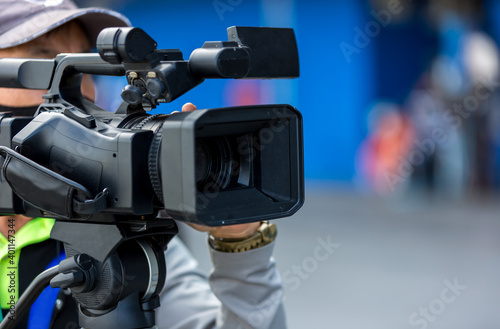 Video camera operator working with his equipment. video cinema production. Covering an event with a video camera. Professional video man hand holding camera operator camcorder working.