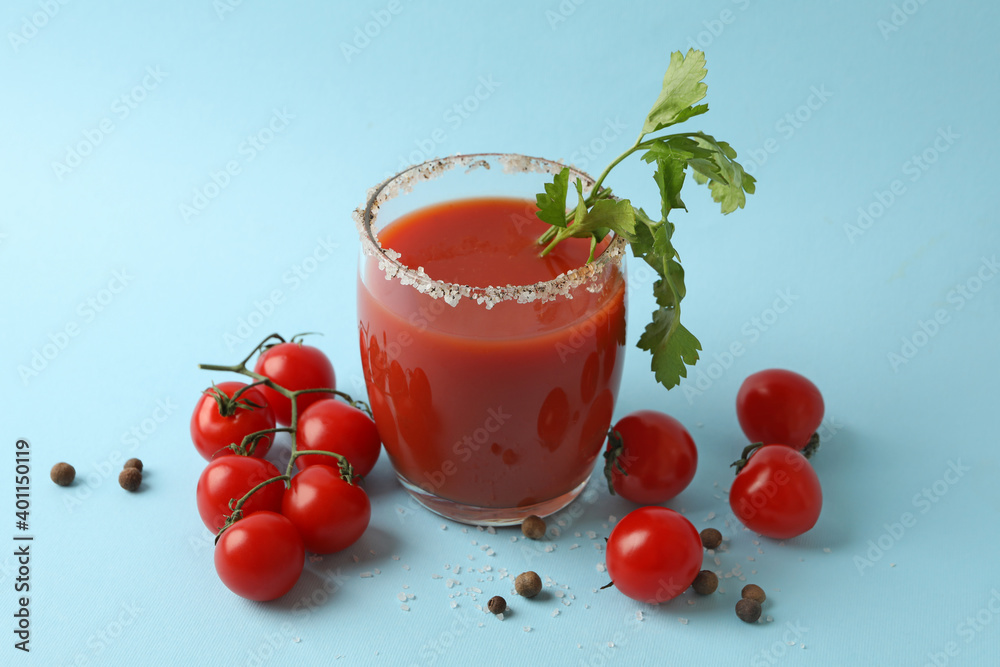 Glass of Bloody Mary and tomatoes on blue background Glass of Bloody Mary and tomatoes on blue background
