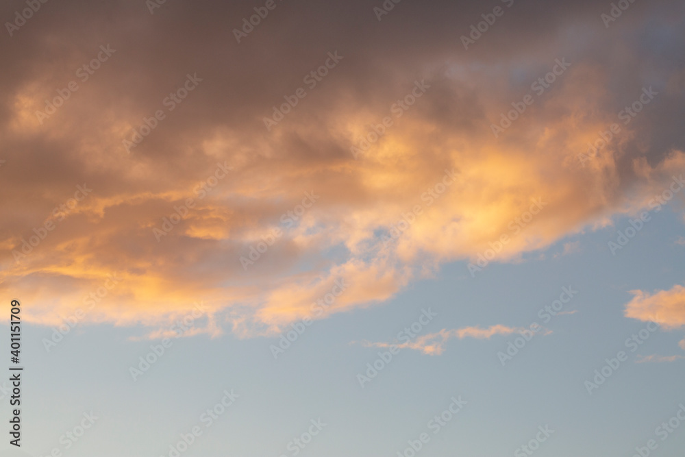 Pale pink clouds against the sunset sky, with copy space. Background. Clouds texture.