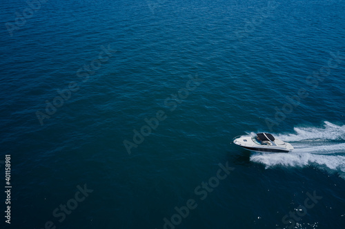 Top view of a white boat sailing to the blue sea. Side view. Motor boat in the sea.Travel - image. © Berg