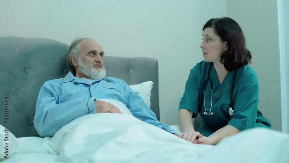Caring nurse holding old male hand, supporting patient, private clinic, service Caring nurse holding old male hand, supporting patient, private clinic, service