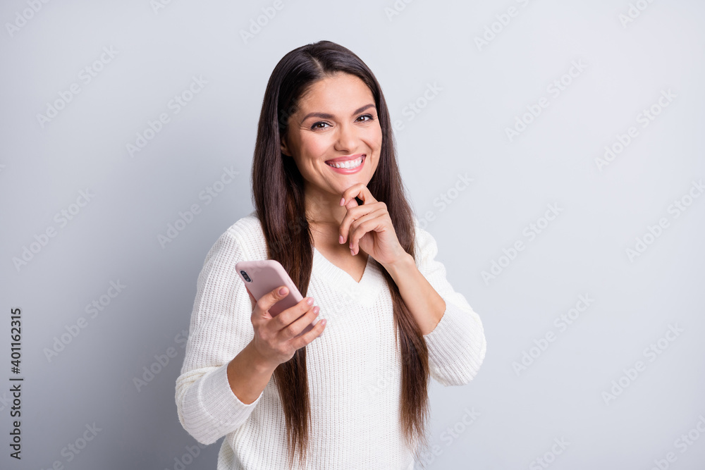 Portrait of charming cheerful brown-haired girl using gadget creating post smm media isolated over grey pastel color background